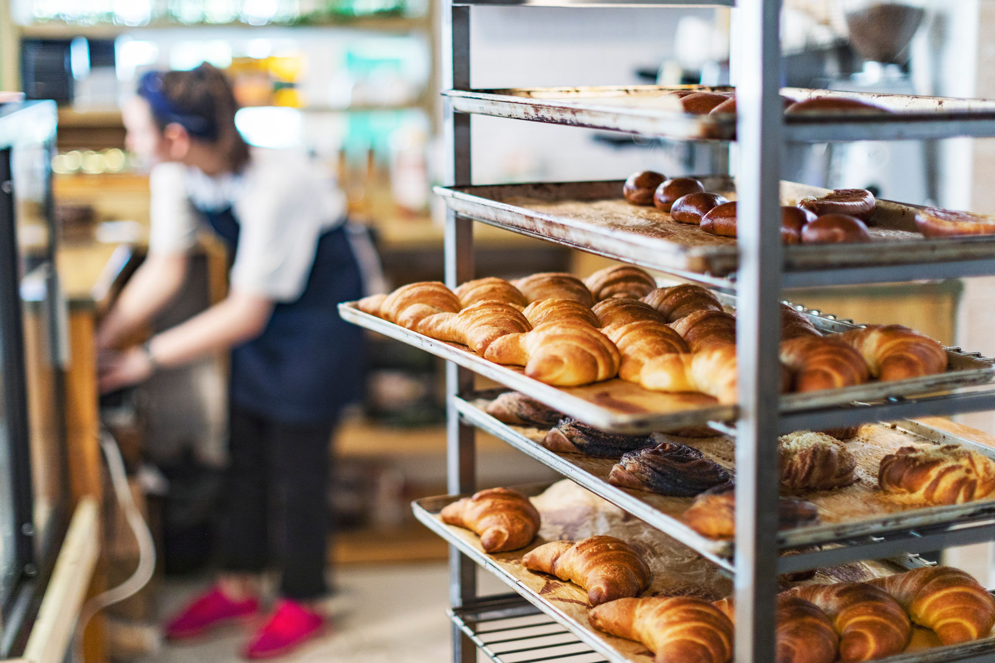 Fresh French bread and croissants in a bakery in cooling rack