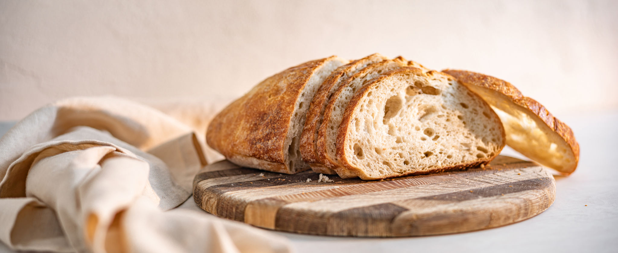 Freshly baked sourdough bread sliced on a wooden cutting board
