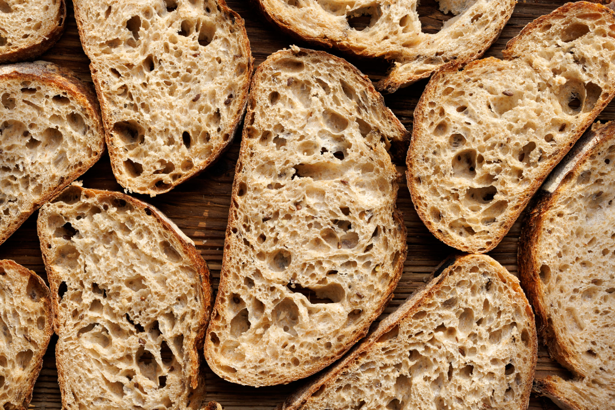 Sourdough bread slices on wooden background top view